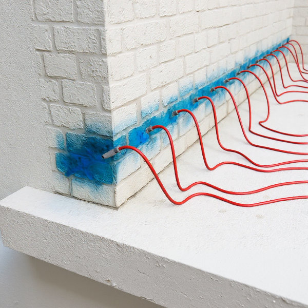 Injektionsverfahren im Keller: Bohrlöcher mit Injektionsdüsen zur Einspritzung von Epoxid-, Paraffin- oder Silikatgel für die horizontale Sperre gegen aufsteigende Feuchtigkeit in feuchten Kellerwänden